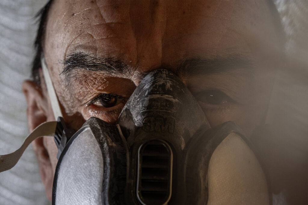 Giorgio, a local resident, wears a mask to shield himself from the noxious fumes of nearby factory farms. Living near an intensive cattle farm, biogas plant, and chicken farm, he has suffered severe nausea, loss of consciousness, and repeated hospital visits. The pollution has shattered his daily life and driven his family away.
