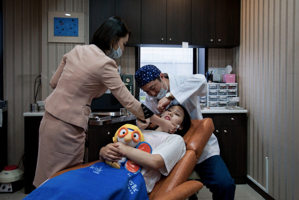 At a cosmetic clinic in Seoul, South Korea, Ju Hyo Jim holds a stuffed toy for comfort during Botox, a protective charm against fear.