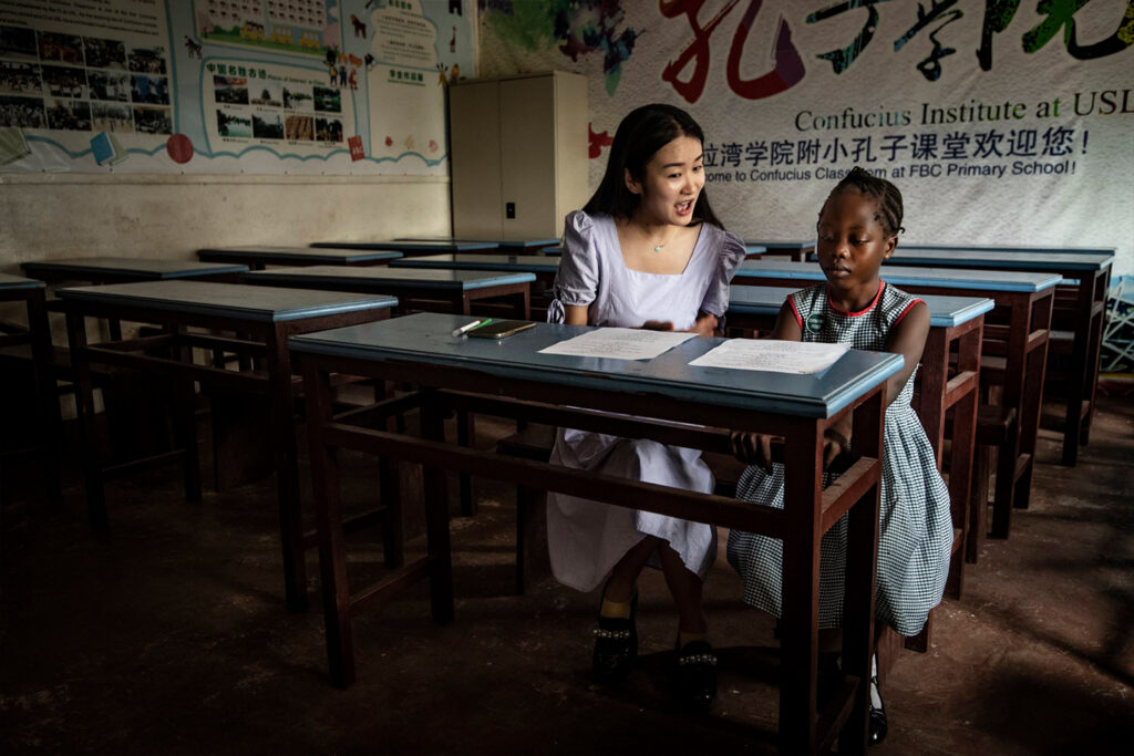 Sylvia, a Chinese teacher from the Confucius Institute, helps Aisha prepare for a Chinese opera competition at Fourah Bay College Primary School.